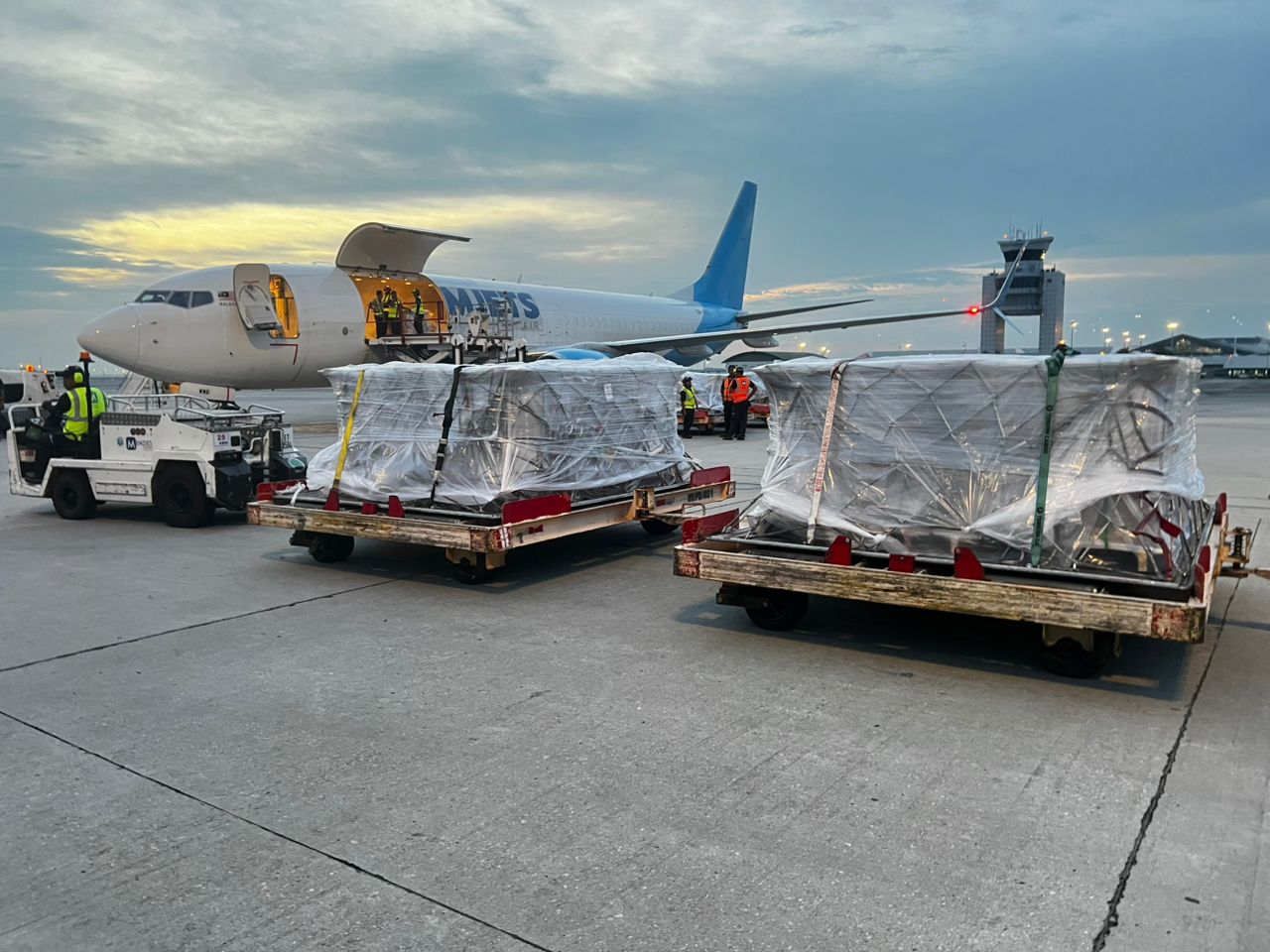 Cargo pallets staged beside a freighter aircraft
