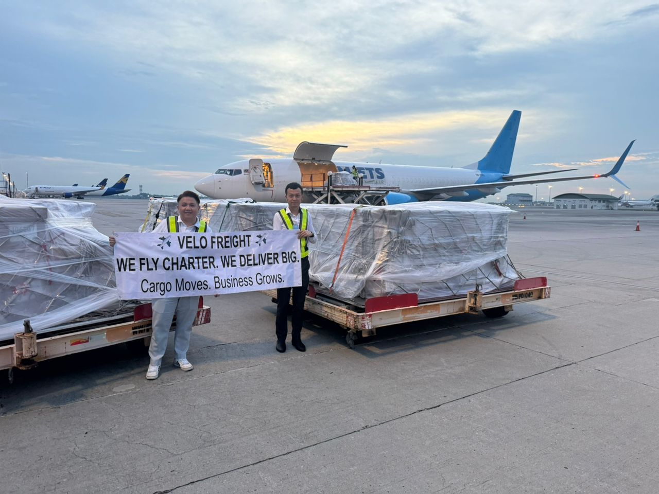 Velo Freight team with charter cargo pallets in front of a freighter
