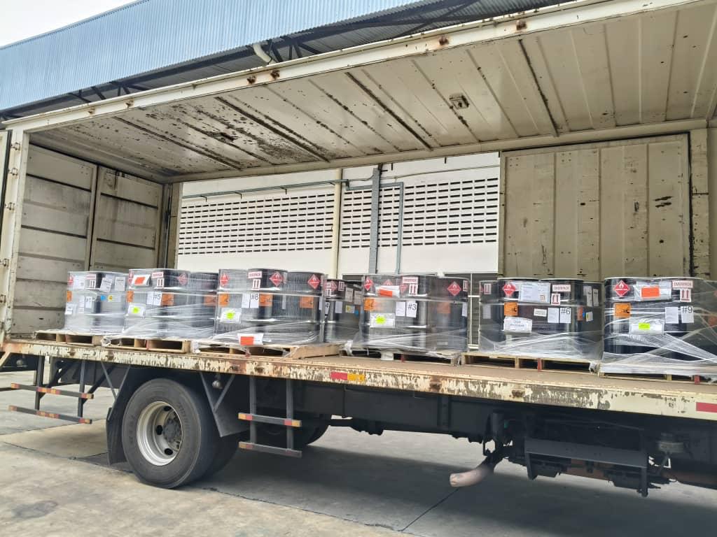 Class-labelled dangerous goods drums on a truck bed